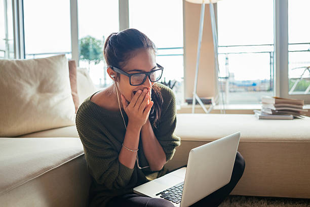 exited and cheerful woman using her laptop,in her cozy living room